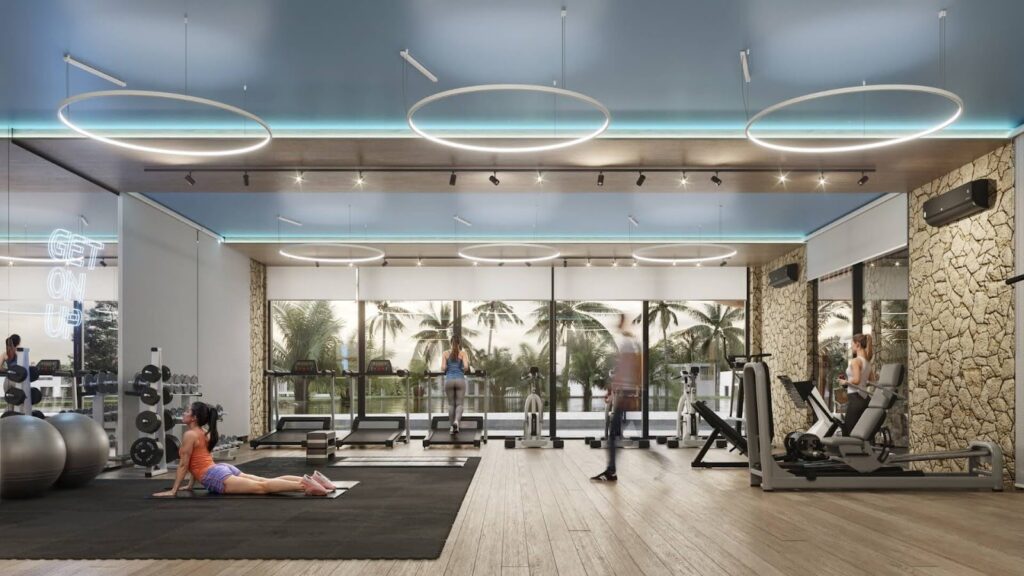 Academia moderna de alto padrão com equipamentos de musculação, esteiras voltadas para o jardim, iluminação em LED circular e paredes com detalhes em pedra.