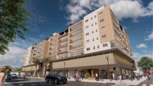 Fachada moderna do edifício Sol y Luna com acabamento em tijolos aparentes e varandas amplas, destacando o andar térreo comercial com pedestres e ciclistas em um dia ensolarado.